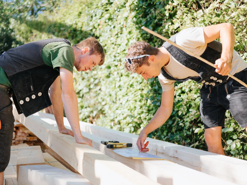 Zimmererteam bei der Arbeit auf einer Holzhaus-Baustelle